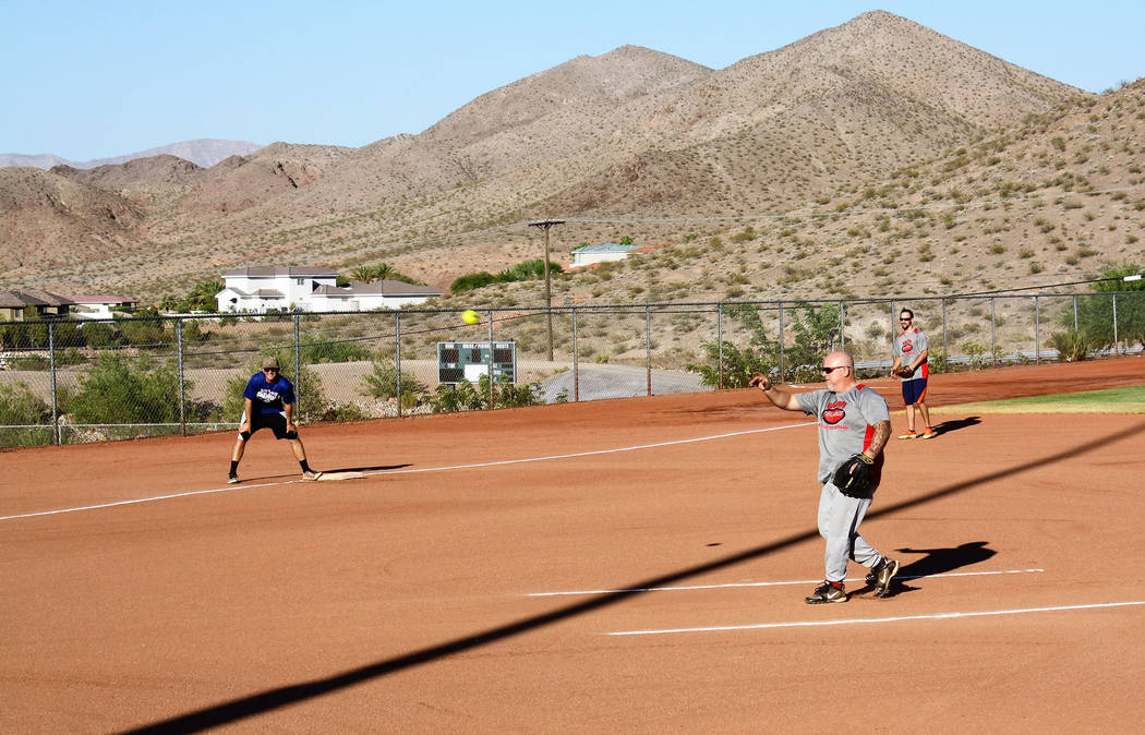 Kelly Lehr
Kel Bartlett from Ralph’s Tires delivers a pitch while teammate Ryan McQuillan looks on at third base in the Boulder City Parks and Recreation Department's men's summer softball league.