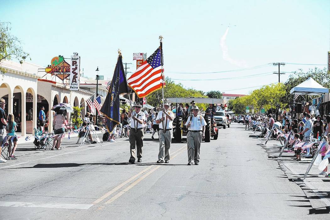 Members of the American Legion, Boulder City Post 31, carry the colors at the start of the 68th annual Damboree parade, as the Boulder City Veterans Flying Group makes its way over head in Boulder ...
