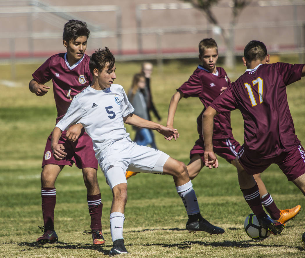 Oksana Saulenko/Boulder City Review
Boulder City High School freshman Julian Balmer strives to keep the ball away from three players from Pahrump Valley in the Eagles' 2-2 tie game on Saturday.