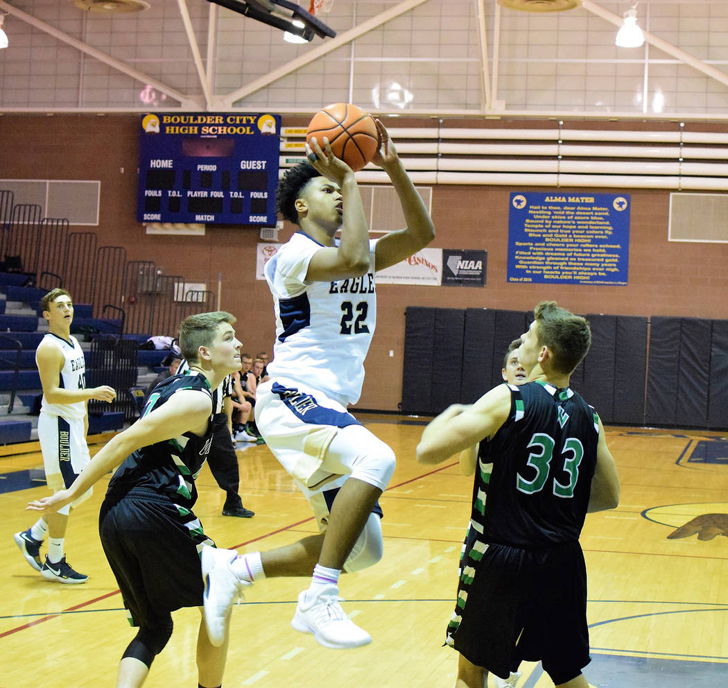 Robert Vendettoli/Boulder City Review
Boulder City High School junior forward Derrick Thomas soars through the air over a pair of Virgin Valley defenders during their Dec. 14 game. Thomas scored a ...