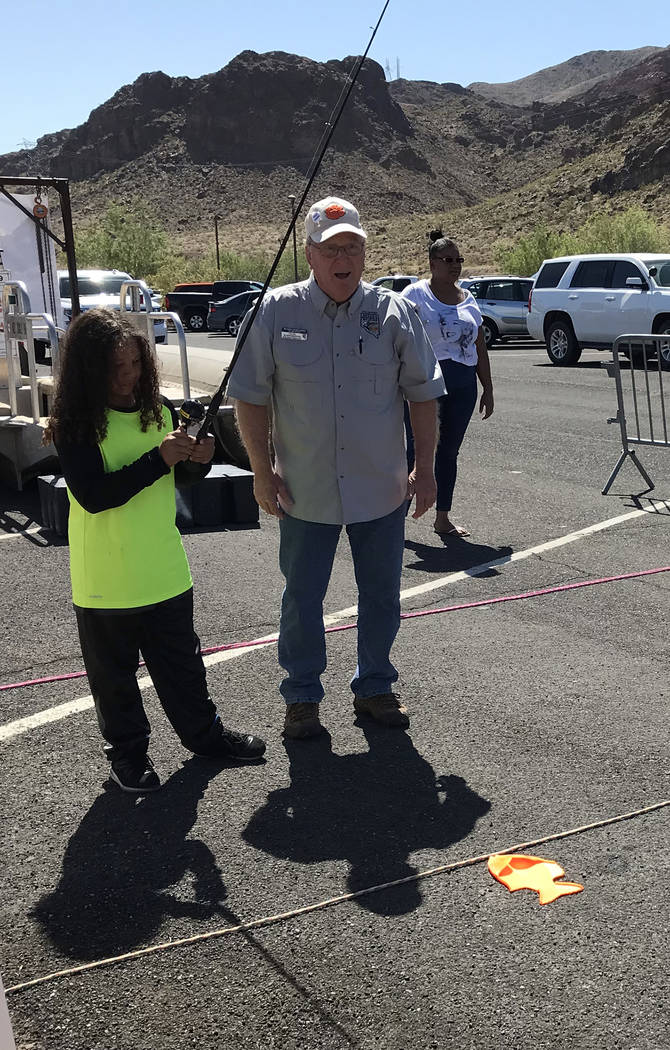 Hali Bernstein Saylor/Boulder City Review Eight-year-old Demetrius Wiest of Las Vegas gets a lesson on how to fish from Craig Schweisinger, a volunteer instructor for the Nevada Department of Wild ...