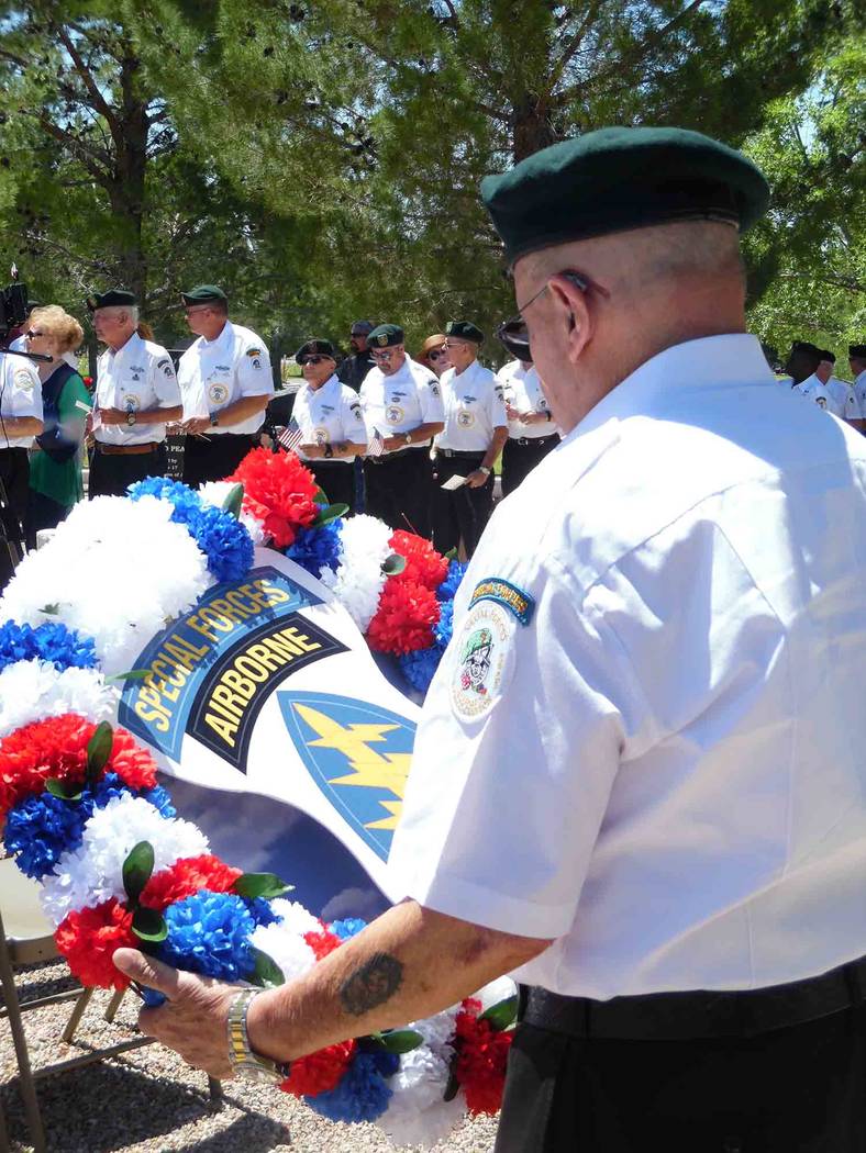 File A member of the Special Forces Association, Chapter 51, prepares to lay a floral wreath during Memorial Day ceremonies in 2017 at the Southern Nevada Veterans Memorial Cemetery. This year's c ...