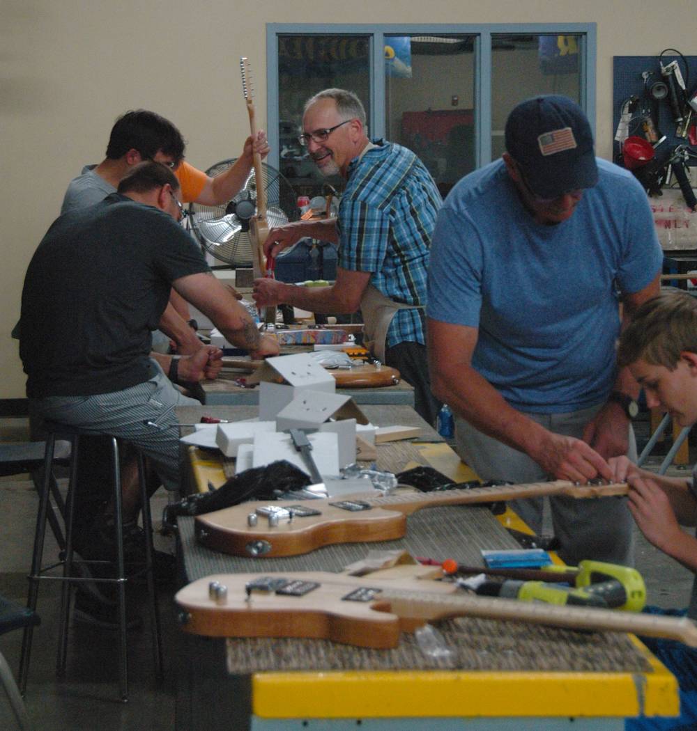 Jayme Sileo/Boulder City Review STEM Guitar summer institute instructor Mike Aikens, second from right, helps Jake Trone, far right, with his electric guitar while Steve Brown, center, guides teac ...