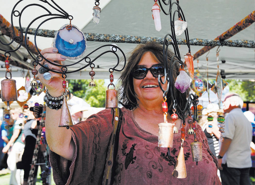 File Kay Koning looks at handmade wind chimes during the 2017 Art in the Park festival in Boulder City's downtown parks. This year's festival will be held from 9 a.m. to 5 p.m. Saturday and Sunday.