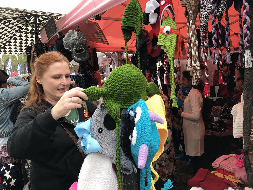 Hali Bernstein Saylor/Boulder City Review Adar Bagus of Las Vegas looks at handmade hats during Art in the Park on Sunday, Oct. 7, 2018. The annual event attracts thousands of people to Boulder Ci ...