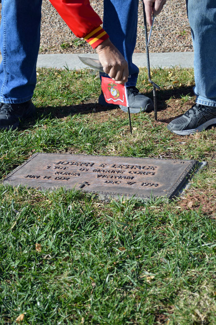 Celia Shortt Goodyear/Boulder City Review Don Ostertag places a United States Marine Corps flag on the grave of veteran at the Southern Nevada Veterans Memorial Cemetery in Boulder City on Friday, ...