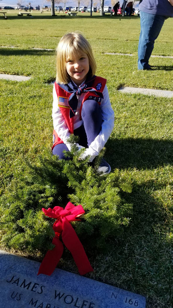 (Celia Shortt Goodyear/Boulder City Review) Seven-year-old Natalie Alexander places a wreath on a veteran's grave at the Southern Nevada Veterans Memorial Cemetery during Wreaths Across America on ...