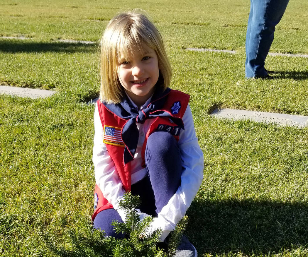 Celia Shortt Goodyear/Boulder City Review Seven-year-old Natalie Alexander places a wreath on a veteran's grave at the Southern Nevada Veterans Memorial Cemetery during Wreaths Across America on S ...