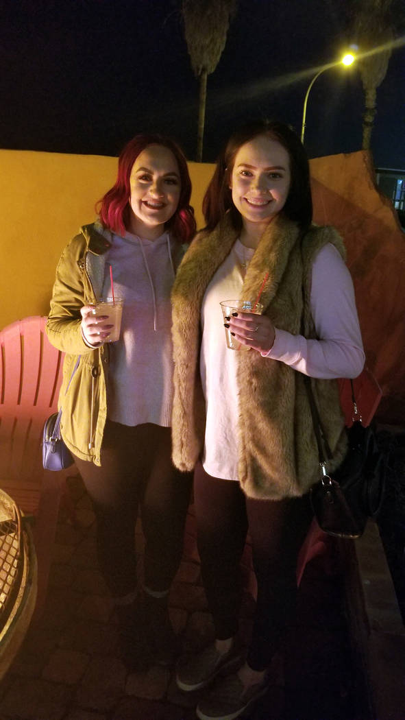 (Celia Shortt Goodyear/Boulder City Review) Tori Humphries, left, and Ashlynn Marlo hang out at the fire during the third annual Xi Zeta Rosie Roll pub crawl on Friday, Feb. 22.