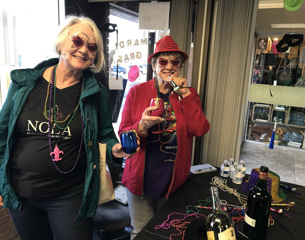 (Hali Bernstein Saylor/Boulder City Review) Boulder City residents Dawn Walker, left, and Jane Mollison get into the spirit of the Mardi Crawl during the Best Dam Wine Walk on Saturday, March 9, 2019.