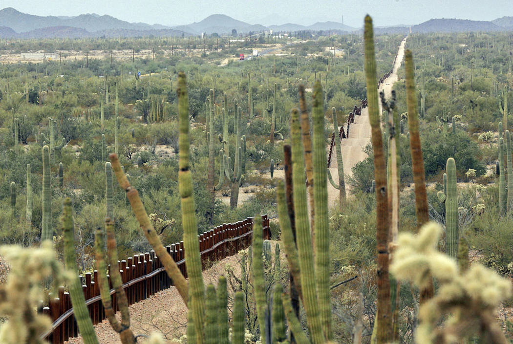 (File) A fence separating Organ Pipe Cactus National Monument, right, and Sonyota, Mexico, is s ...