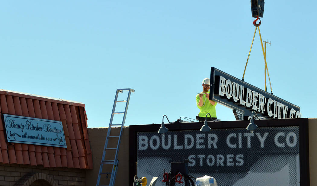 (Celia Shortt Goodyear/Boulder City Review) A worker with High Impact Signs installs a new sign ...