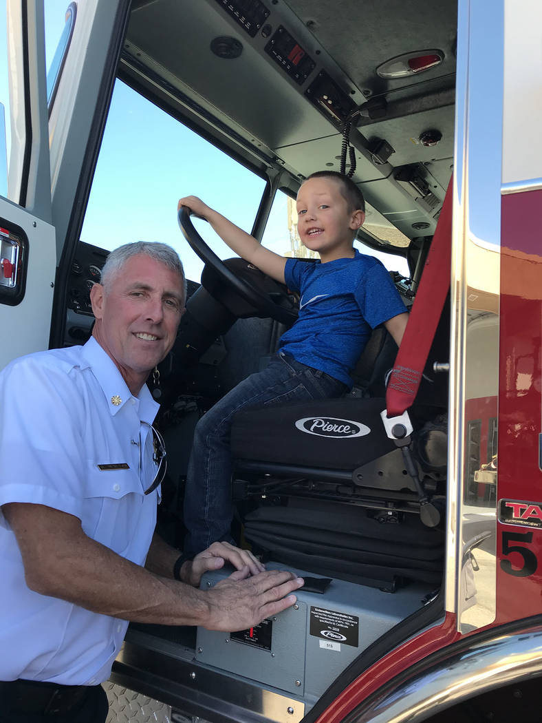 (Hali Bernstein Saylor/Boulder City Review) Interim Fire Chief Steve Walton shows his grandson ...