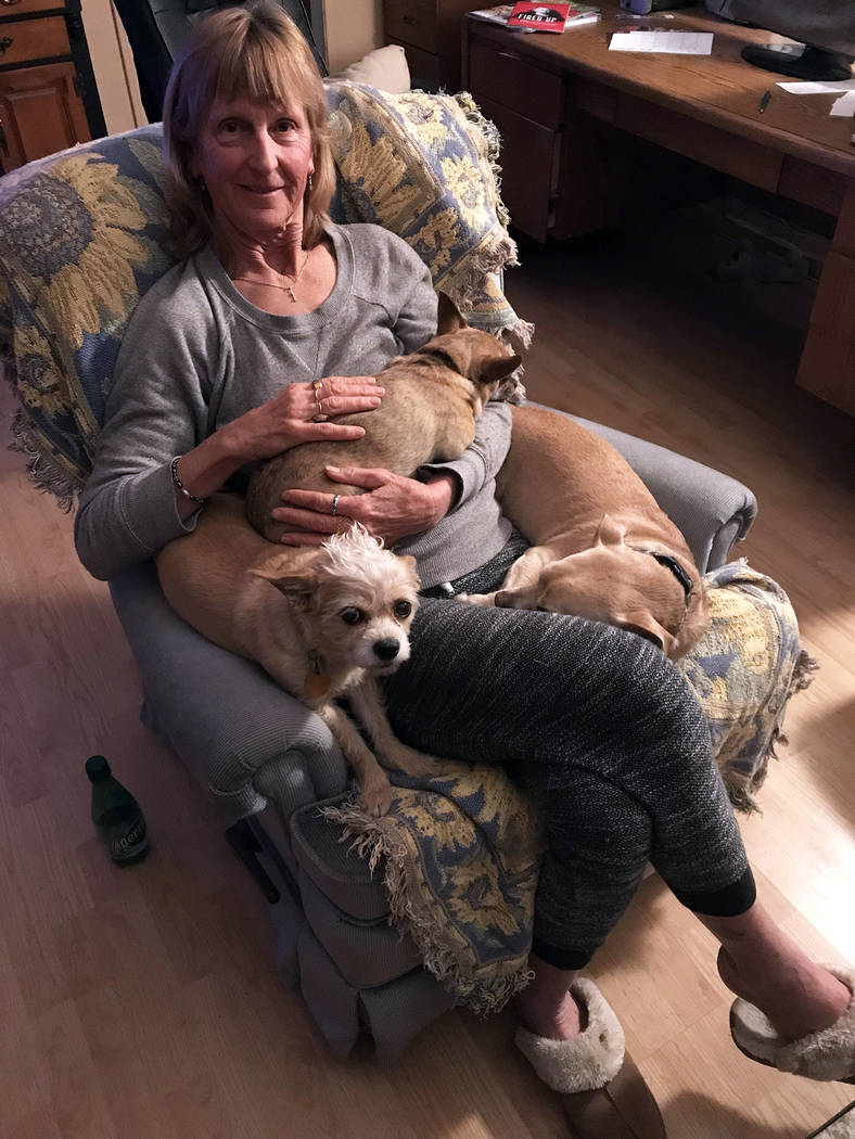 (Sara Carroll) Sara Carroll relaxes at home with a few of the dogs she has adopted from Boulder ...