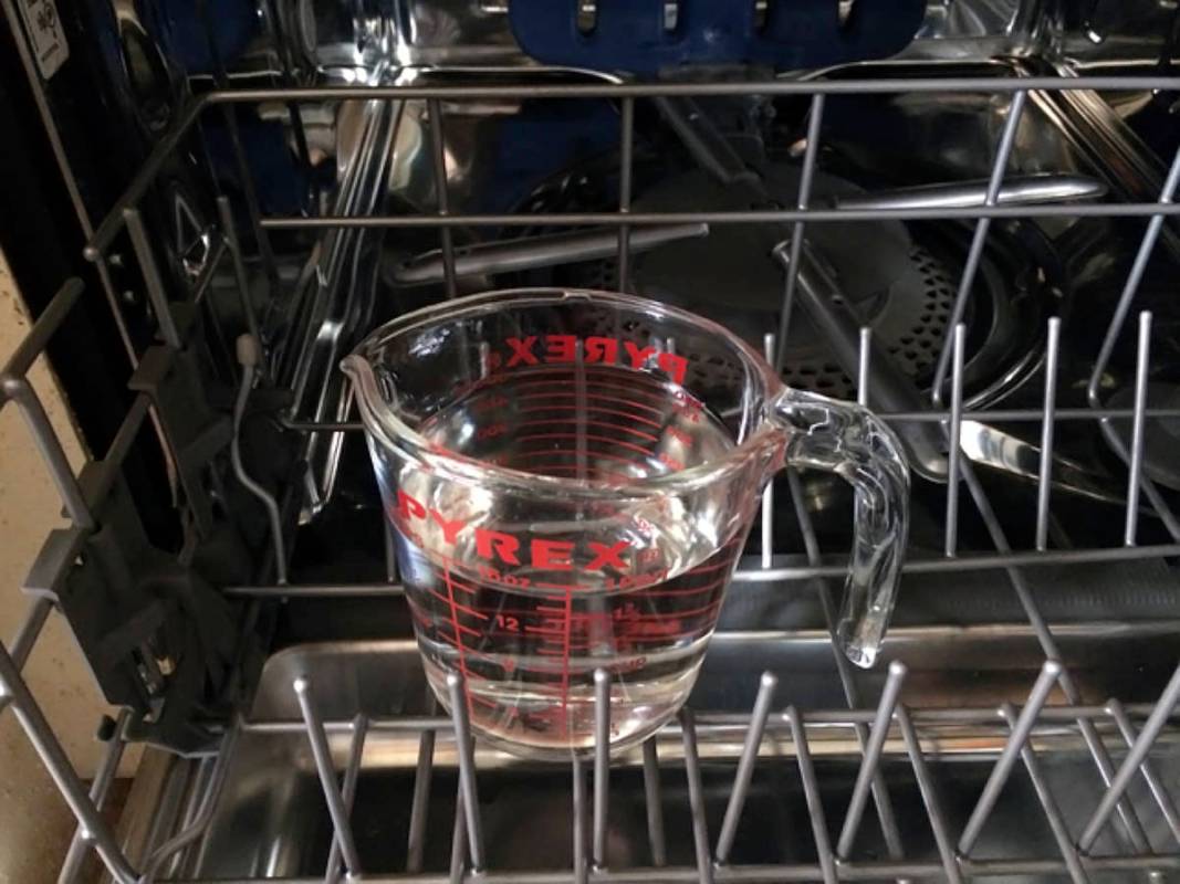 (Norma Vally) Clean your dishwasher by placing 2 cups of white distilled vinegar in a container ...