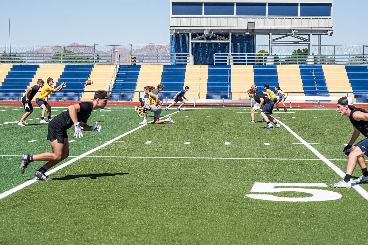 Members of Boulder City High School’s varsity football team, seen running drills in July, are ...