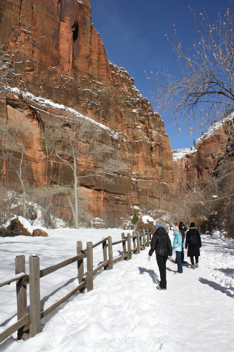 (Deborah Wall) Visitors hike along the snow-covered Riverside Walk in Zion Canyon in the Utah n ...