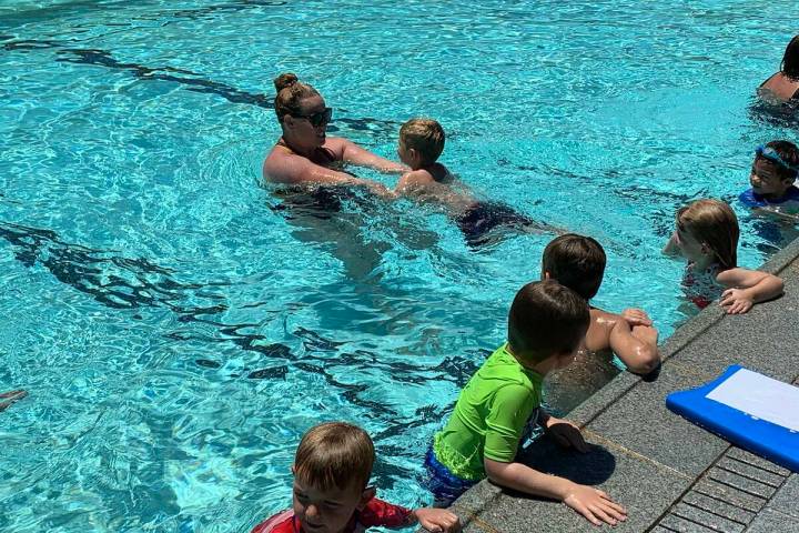 (Hali Bernstein Saylor/Boulder City Review) Katie Tyler helps a young boy learn how to swim saf ...