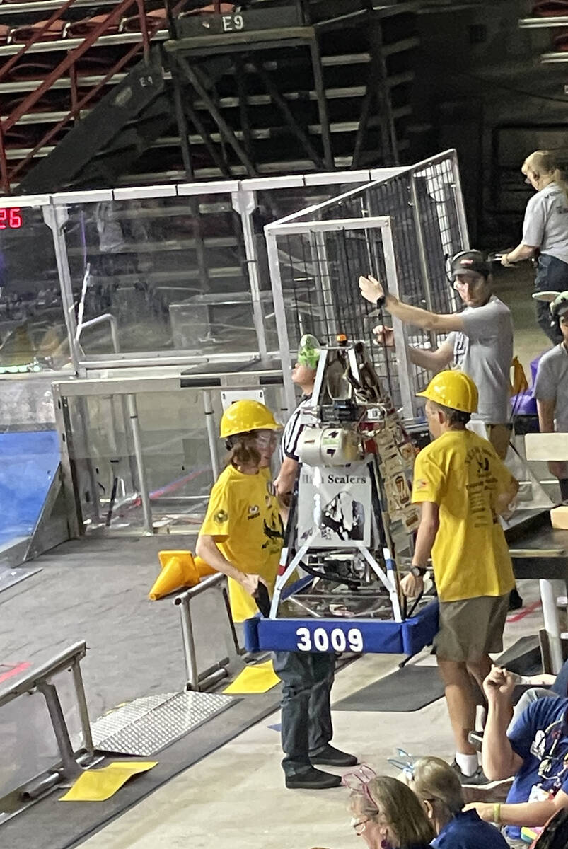 Team members Colin Vollmer and Ben Porter carry the robot into the arena. Thomas and Mack Cente ...