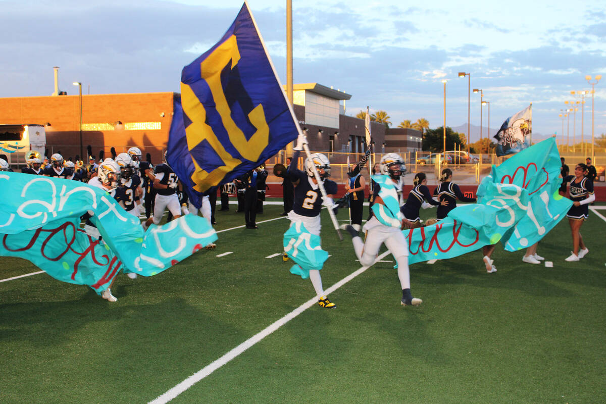 Photos by Ron Eland/Boulder City Review Senior Derek Render (2) leads his team onto the field ...