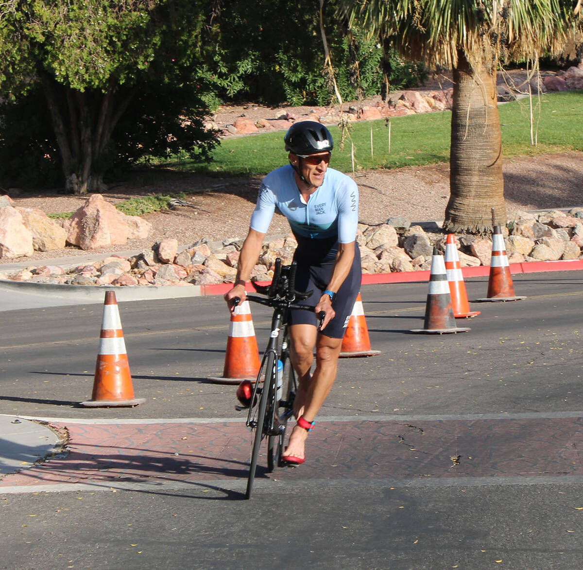 Grullan Luigi prepares to dismount from his bike before the run portion of the sprint triathlon ...