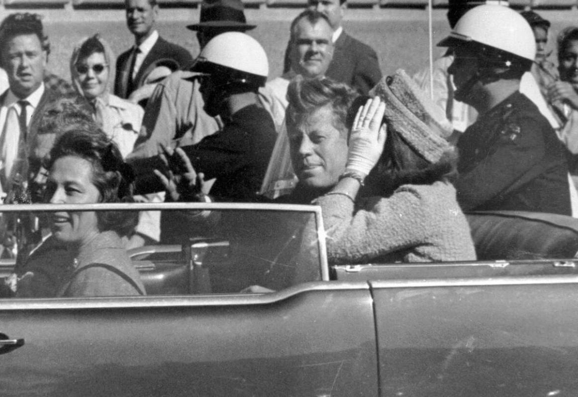 FILE - In this Nov. 22, 1963 file photo, President John F. Kennedy waves from his car in a moto ...