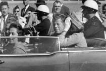 FILE - In this Nov. 22, 1963 file photo, President John F. Kennedy waves from his car in a moto ...