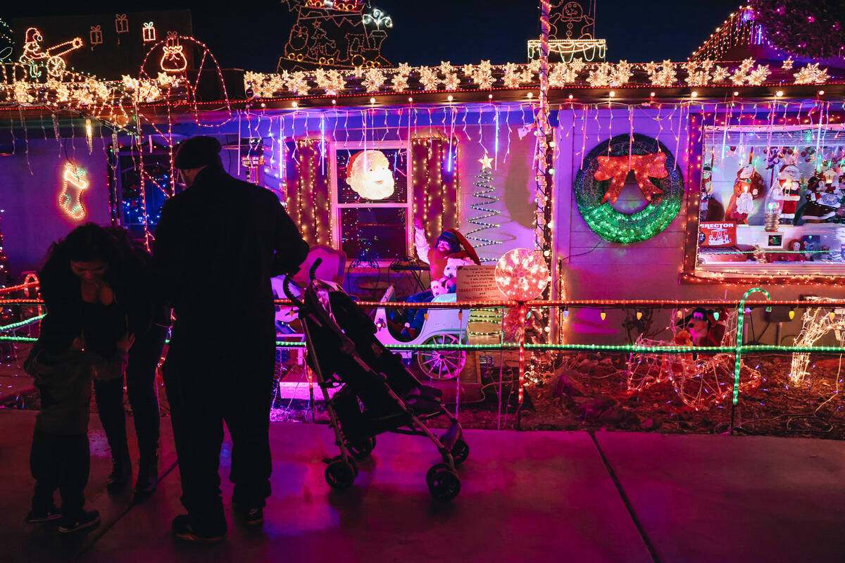 A family looks at Christmas lights at the home of Dale Ryan and Dyanah Musgrave on Sunday, Dec. ...
