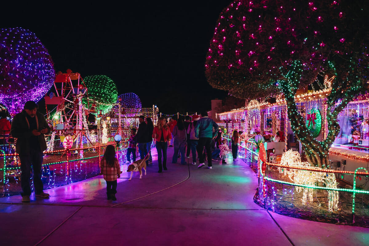 People stroll through the yard of Dale Ryan and Dyanah Musgrave on Sunday, Dec. 3, 2023, in Bou ...