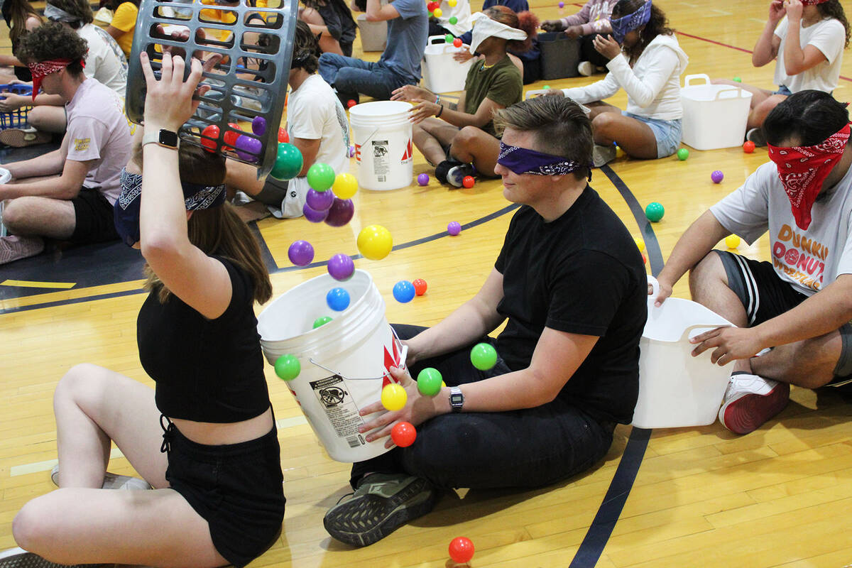 Senior Sterling Morris, center, receives a basket of plastic balls from a classmate during one ...