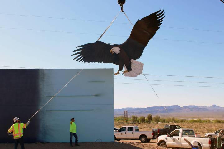 City crews help align the eagle at the new welcome sign Monday morning. The $75,000 sign, which ...