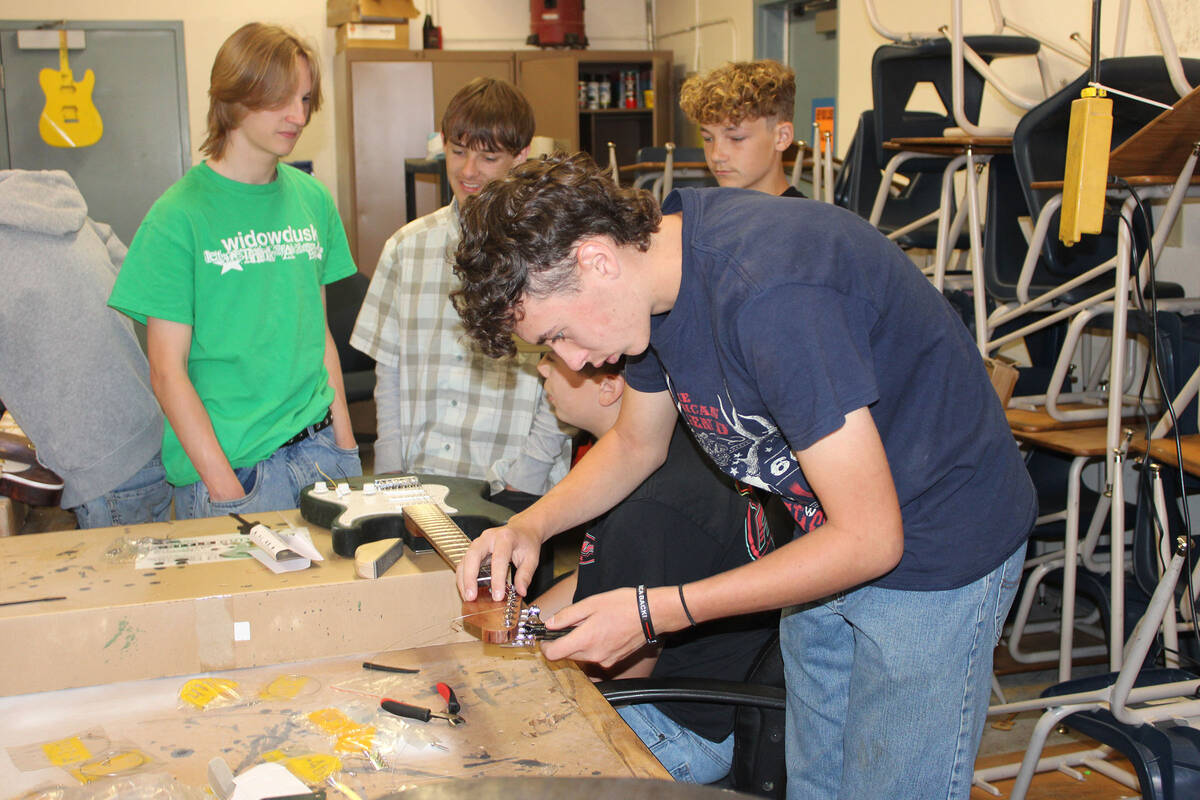 Connor Ziemba puts the finishing touches on his guitar Monday.