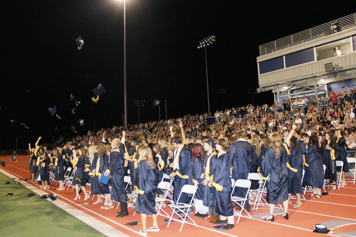 The class of 2024 watches as some launched their caps into the air on what turned out to be a n ...