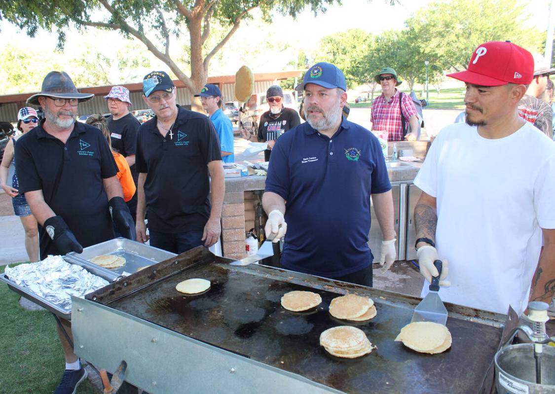 Nevada State Treasurer Zach Conine shows his pancake flipping skills Thursday. He was one of ma ...