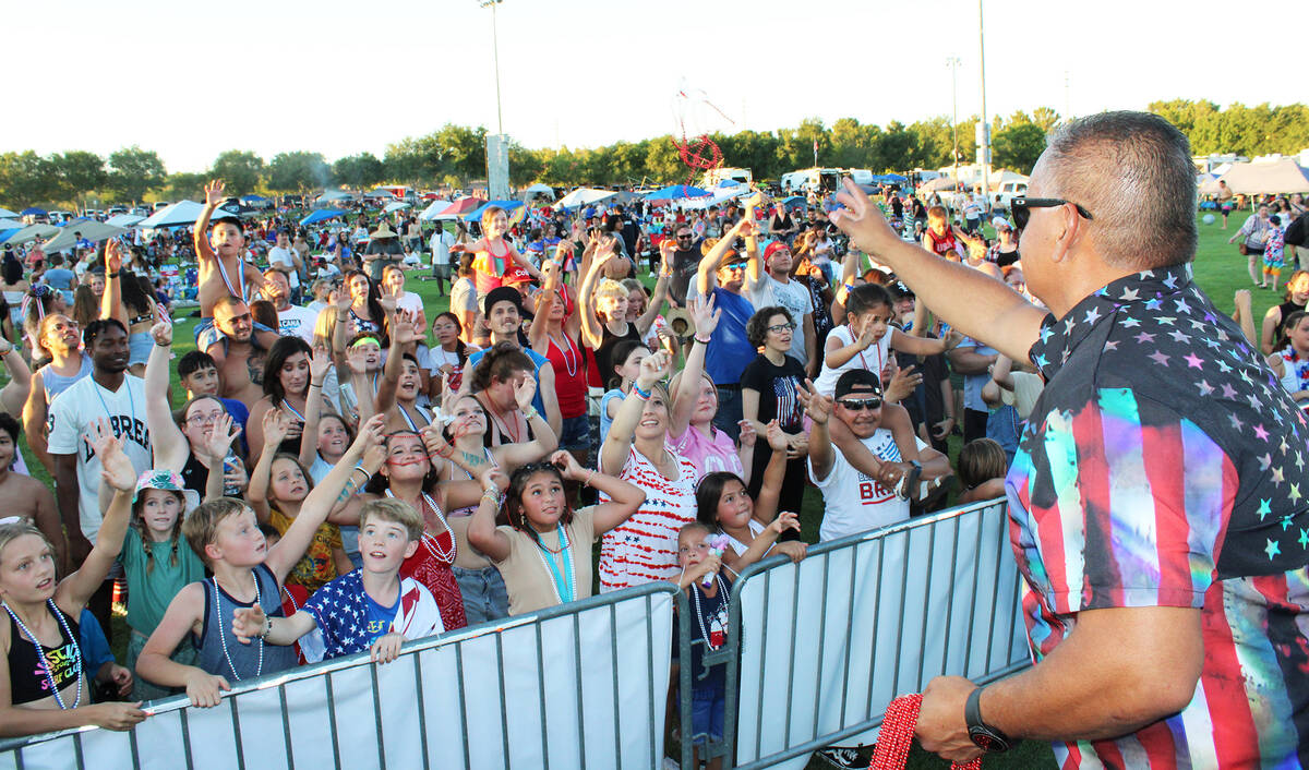 Emcee Mike Pacini, who has been entertaining Damboree attendees for years, tosses beads to the ...