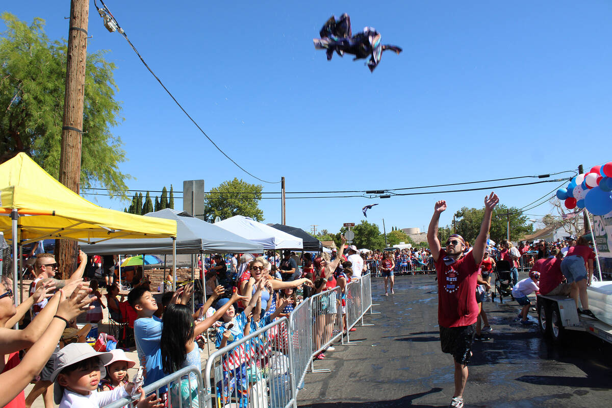 Representative from the Boulder Dam Credit Union tossed wet cloths into the crowd to help cool ...