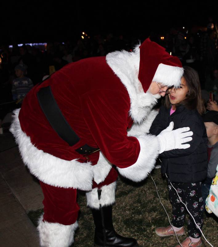 Santa takes a moment to listen to a young girl’s Christmas wish.