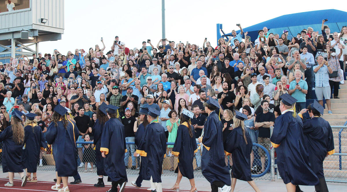 Before a standing-room-only crowd at Bruce Eaton Field, the students enter in front of family a ...