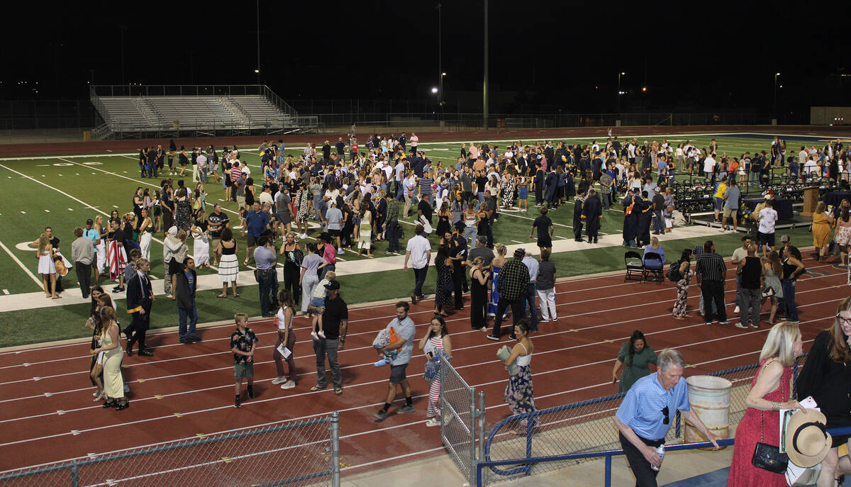 Family and friends begin to leave the field after meeting with the graduates for hugs and photos.