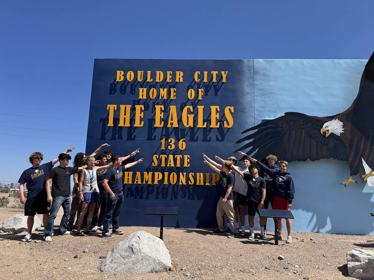 Photo courtesy BCHS Members of the BCHS boys swim team point at the updated state championship ...