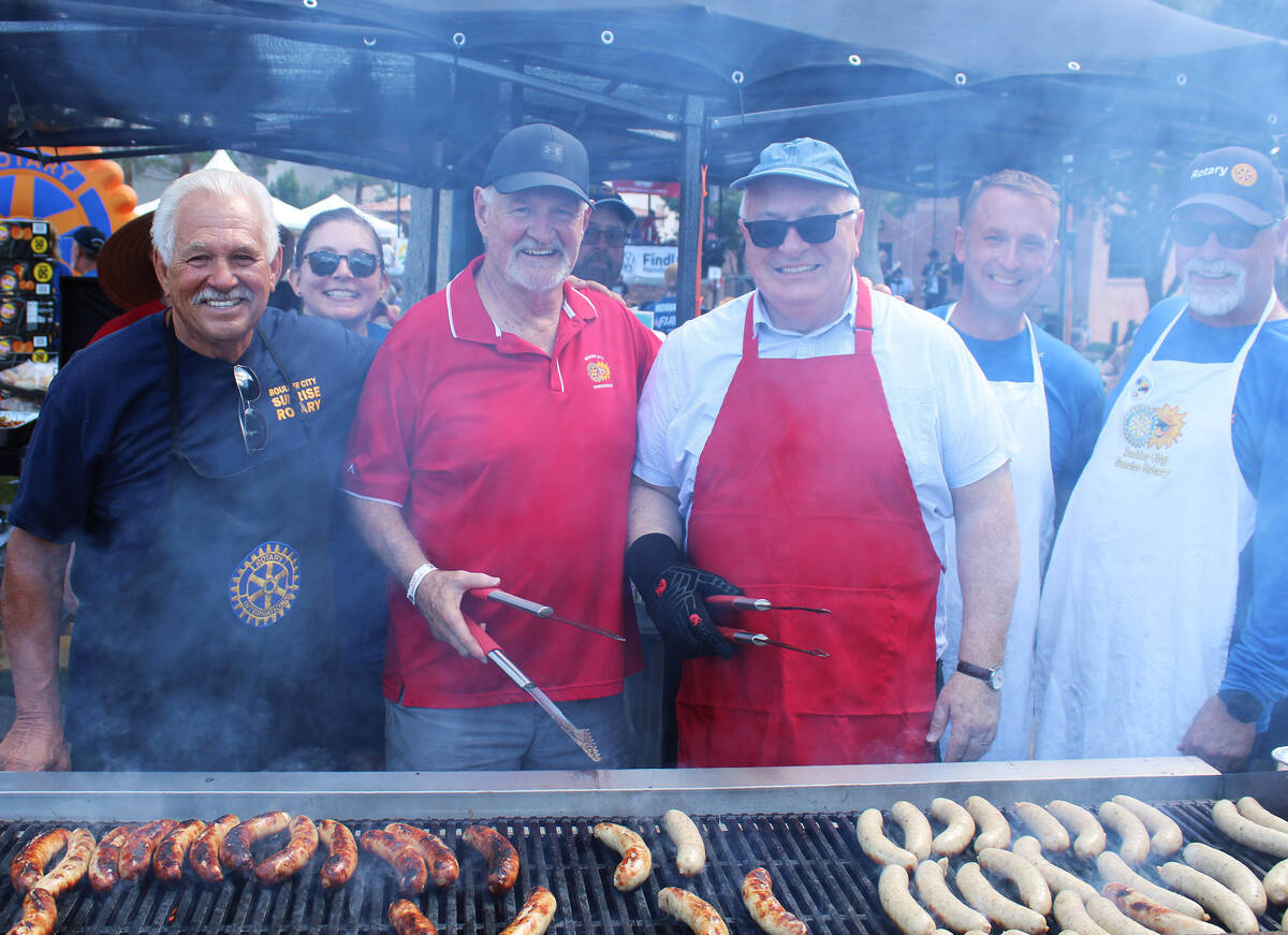 Members of Boulder City Sunrise Rotary fight off the smoke to show off the stars and namesake o ...