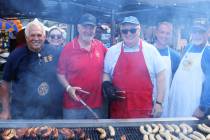Members of Boulder City Sunrise Rotary fight off the smoke to show off the stars and namesake o ...