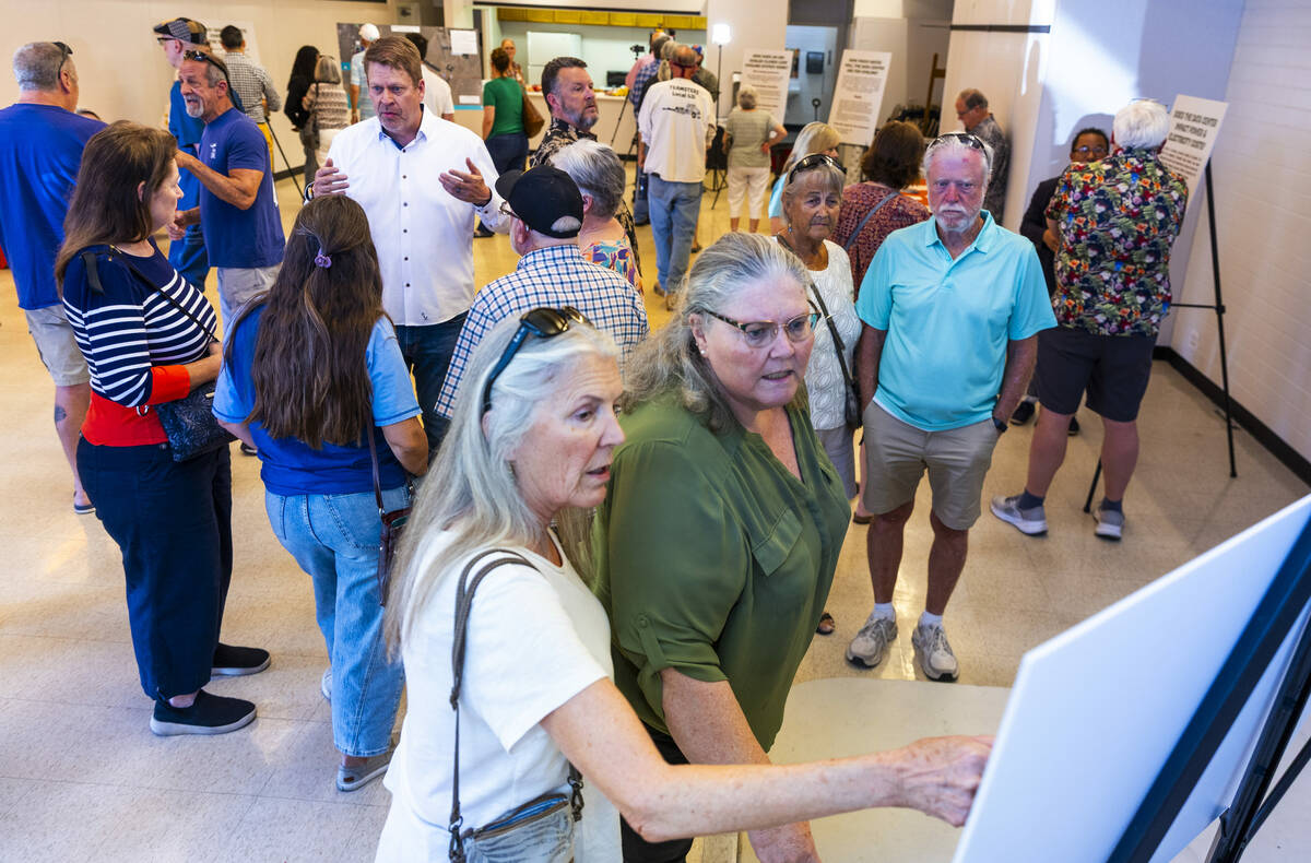 Residents and other concerned citizens look at information boards during a proposed data center ...