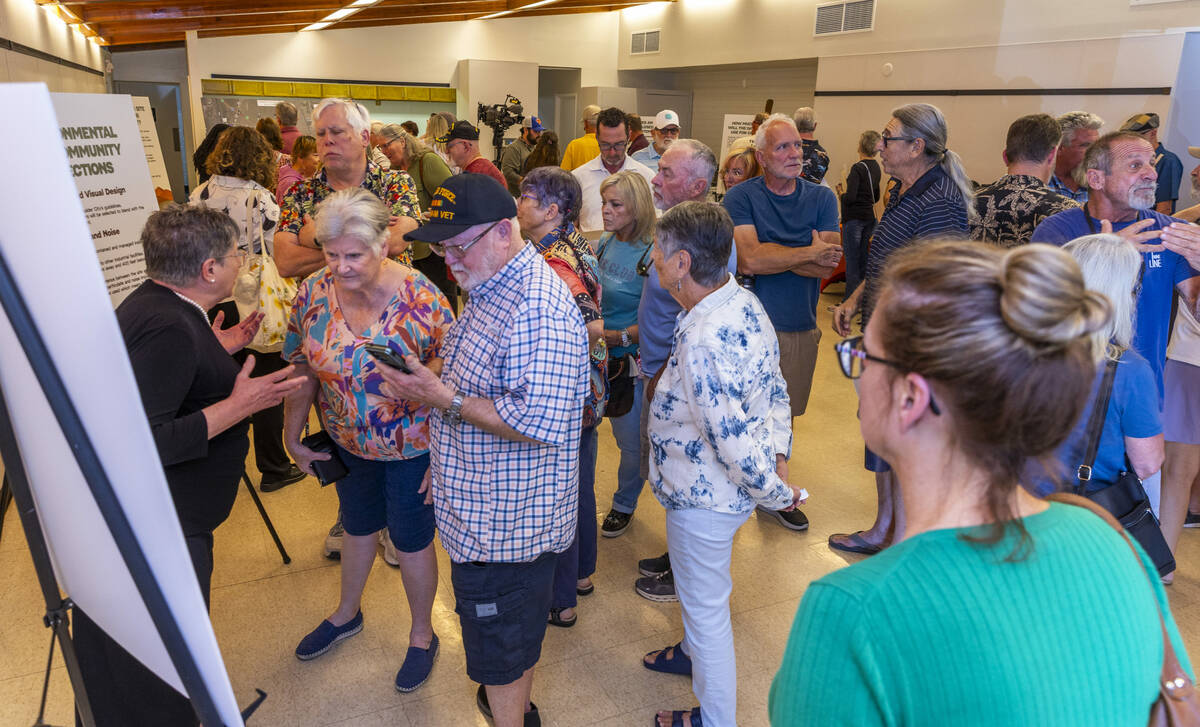 Residents and other concerned citizens talk to each other and look at information boards during ...