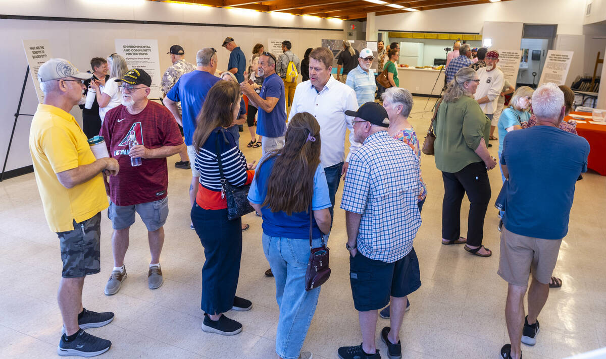 Residents and other concerned citizens talk to each other and look at information boards during ...