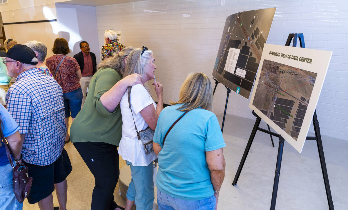 Residents and other concerned citizens look at information boards during a proposed data center ...