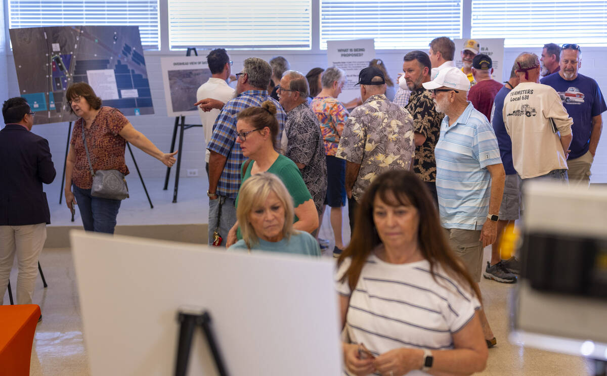 Residents and other concerned citizens talk to each other and look at information boards during ...