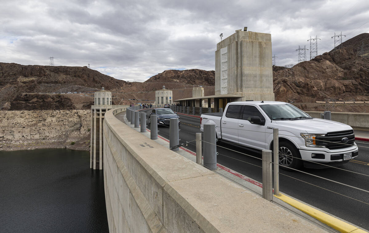The Colorado River is seen as vehicles drive along Hoover Dam on Sunday, April 26, 2026, outsid ...