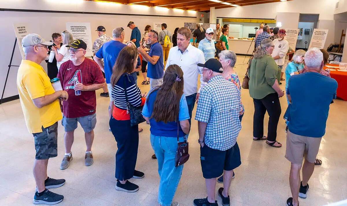 Residents and other concerned citizens talk to each other and look at information boards during ...
