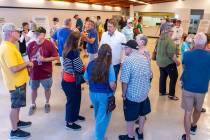 Residents and other concerned citizens talk to each other and look at information boards during ...